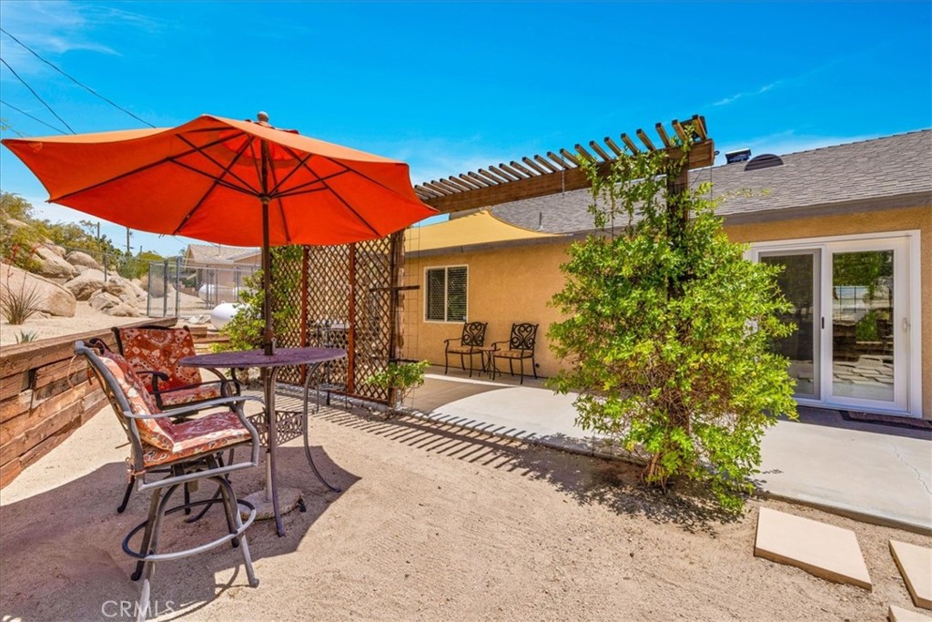 57490 Redondo Street Yucca Valley, CA 92284 - Photo 40 of 60 a view of patio with chairs and table under an umbrella