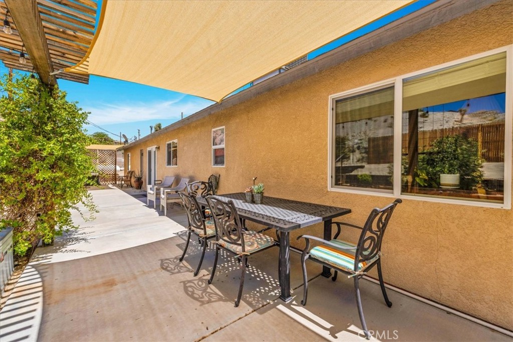57490 Redondo Street Yucca Valley, CA 92284 - Photo 41 of 60 a patio with table and chairs and potted plants