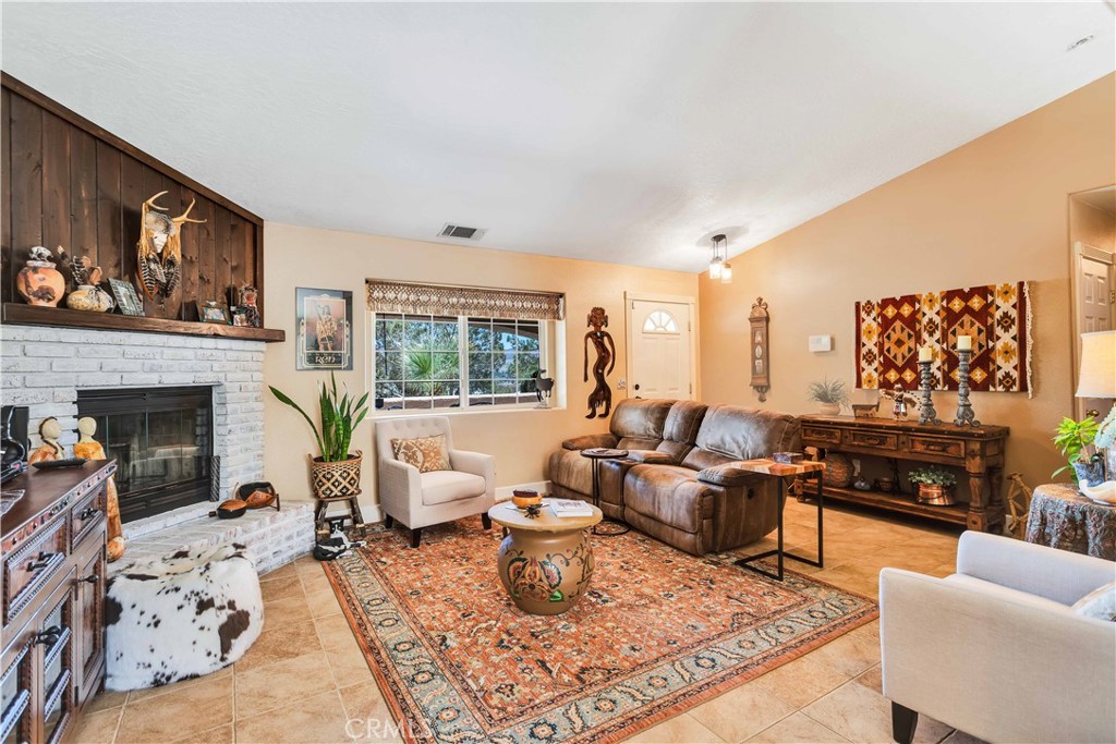 57490 Redondo Street Yucca Valley, CA 92284 - Photo 10 of 60 a living room with furniture large window and a fireplace