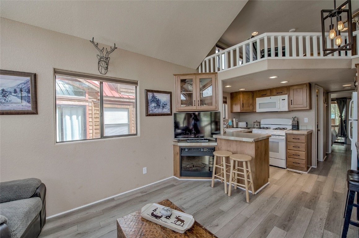 122 Sunshine Loop Fairplay, CO 80440 - Photo 4 of 28 a kitchen with stainless steel appliances granite countertop a stove top oven a sink a dining table and chairs with wooden floor