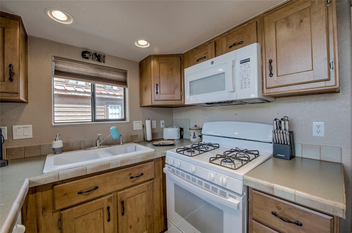 122 Sunshine Loop Fairplay, CO 80440 - Photo 7 of 28 a kitchen with granite countertop a sink stove and cabinets
