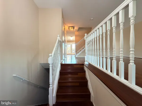 a view of staircase with lots of frames on wall and a window
