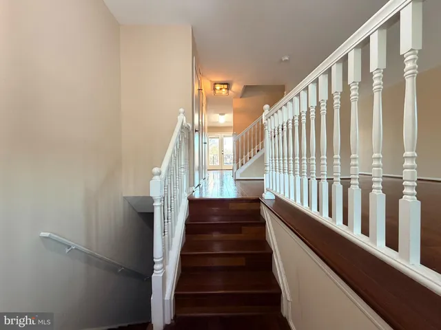 a view of staircase with lots of frames on wall and a window