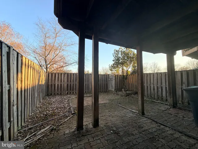 a view of a backyard with floor to ceiling window and wooden fence