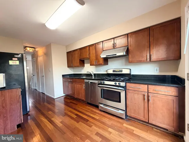 a kitchen with stainless steel appliances granite countertop a stove a sink and a refrigerator