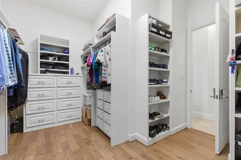 a view of walk in closet with clothes and shoes