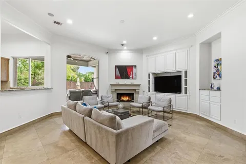 a living room with furniture a flat screen tv and a fireplace