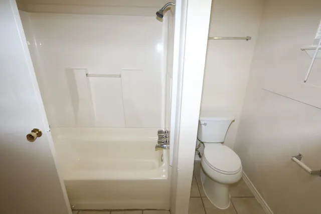 a white toilet sitting next to a bath tub