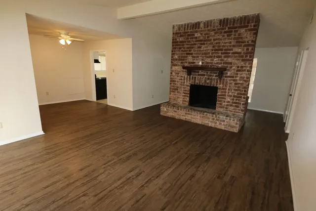 a view of a livingroom with wooden floor and a fireplace