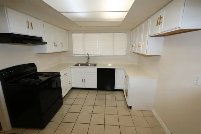 a kitchen with a sink a stove and cabinets