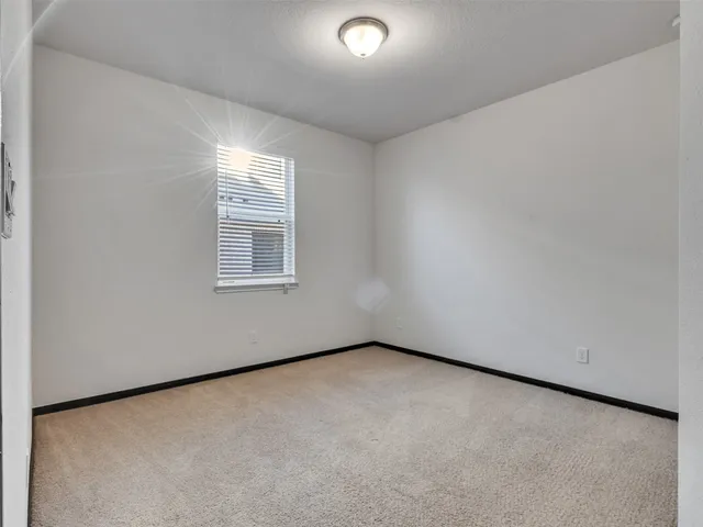 a view of kitchen with stainless steel appliances granite countertop a refrigerator sink and white cabinets