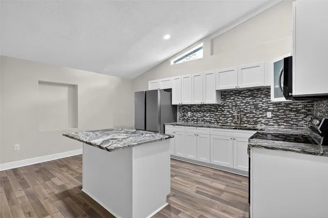 a view of kitchen island with granite countertop cabinets