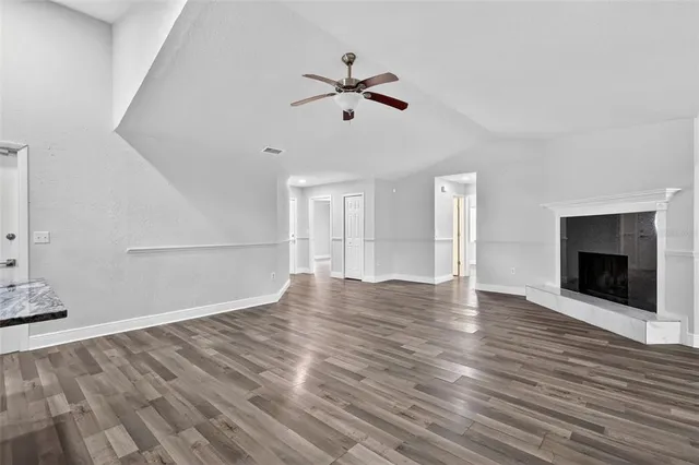 a view of empty room with wooden floor and fireplace