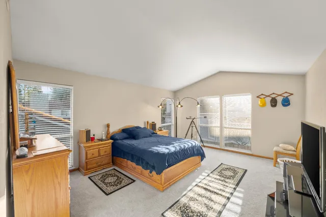 a living room with a bed furniture computer and a window