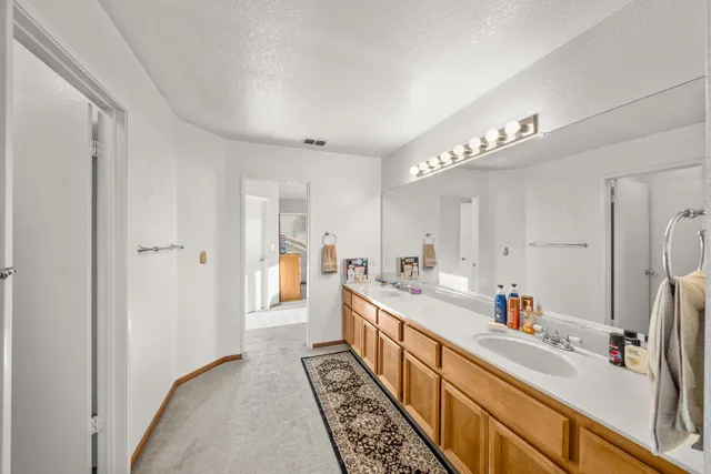 a large white kitchen with stainless steel appliances a sink and a refrigerator