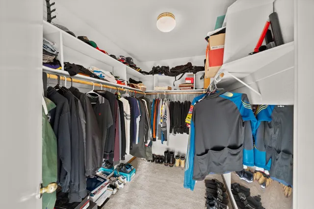 a view of walk in closet with clothes and shoes