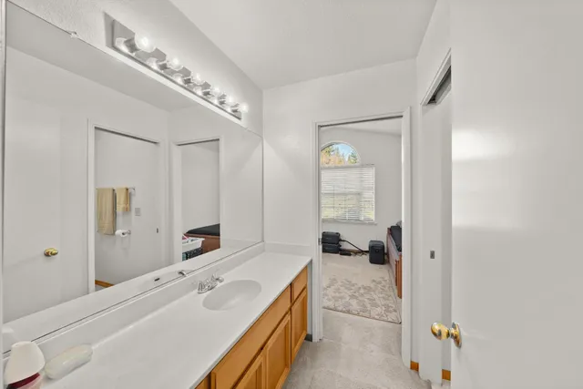 a spacious bathroom with a double vanity sink a mirror and a bathtub