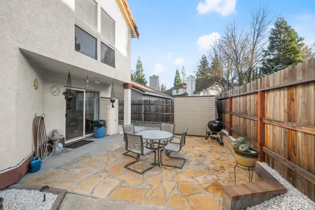 a view of a patio with couches table and chairs potted plants