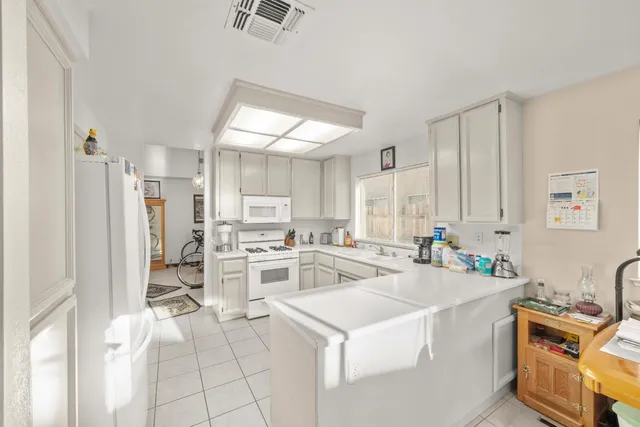 a view of a kitchen with a sink dishwasher stove top oven and cabinets