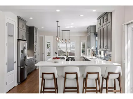 a kitchen with kitchen island granite countertop a sink and refrigerator