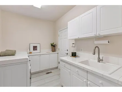 a kitchen with white cabinets sink and stove