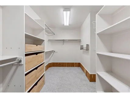 a view of walk in closet with empty racks