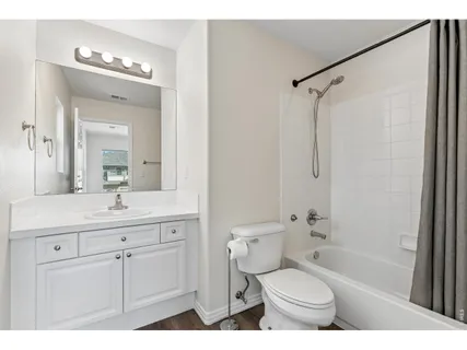 a bathroom with a granite countertop sink toilet a shower a mirror and a bathtub