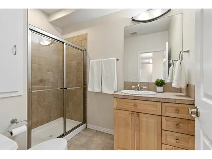 a bathroom with a shower sink and mirror