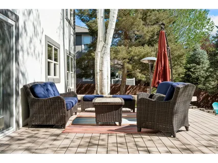 a view of a patio with couches chairs and a wooden floor
