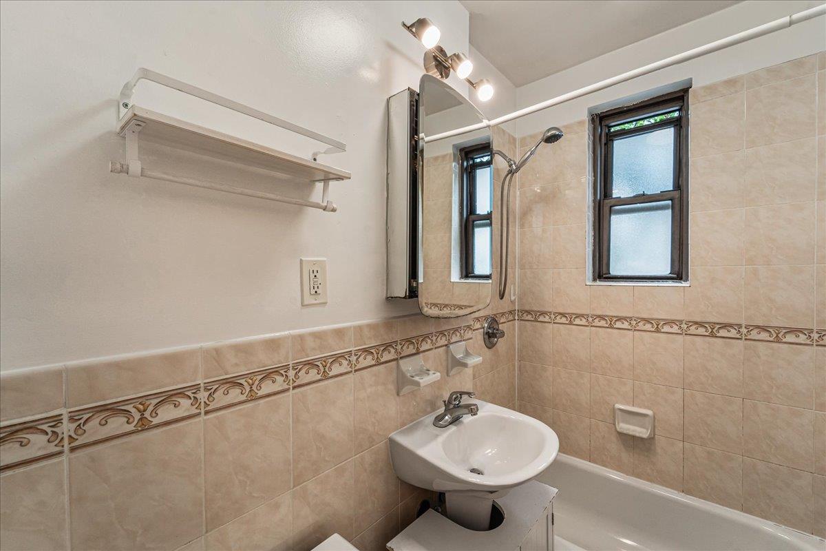 21-37 33rd Street, Unit 3D Queens, NY 11105 - Photo 12 of 15 a bathroom with a shower sink and mirror