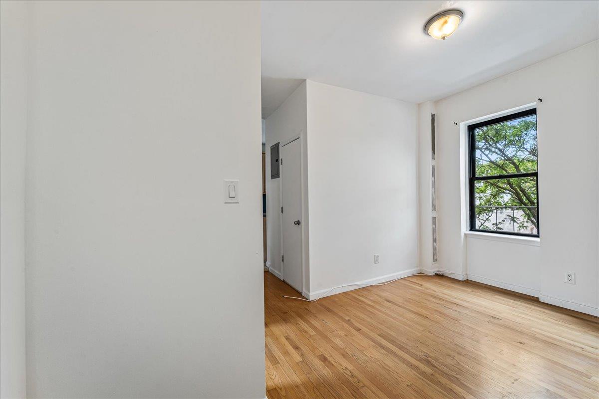 21-37 33rd Street, Unit 3D Queens, NY 11105 - Photo 4 of 15 an empty room with wooden floor and windows