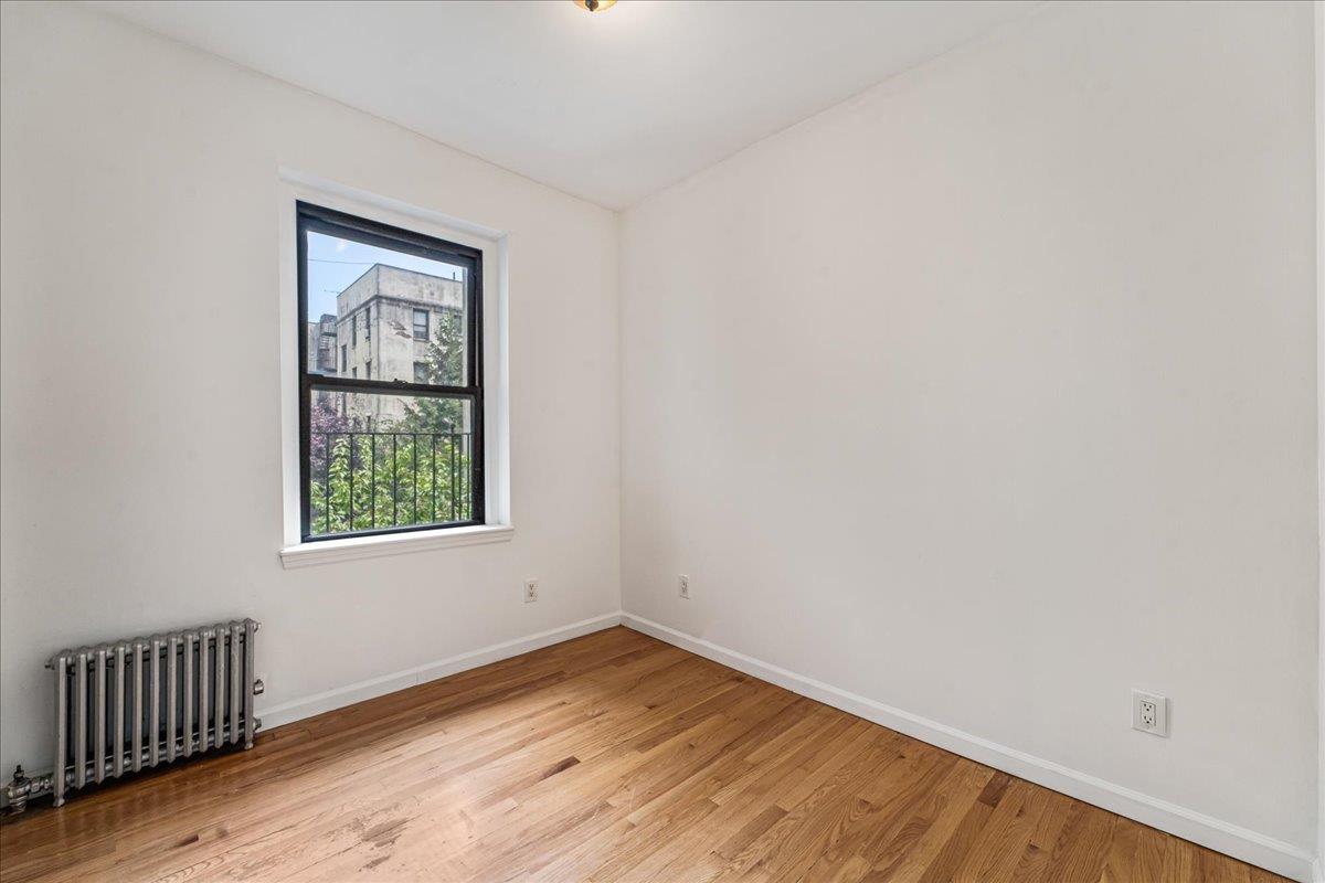 21-37 33rd Street, Unit 3D Queens, NY 11105 - Photo 6 of 15 an empty room with wooden floor and windows