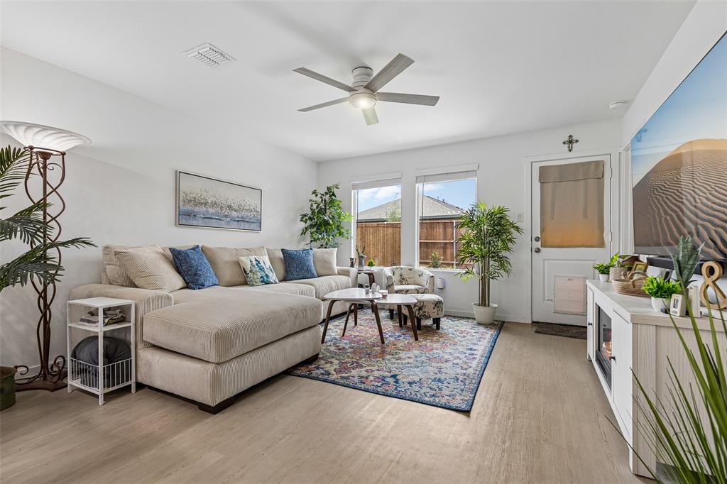 14163 Kempt Drive Pilot Point, TX 76258 - Photo 11 of 29 The inviting living room features a ceiling fan, abundant natural light, and a convenient doggy door with direct access to the backyard.