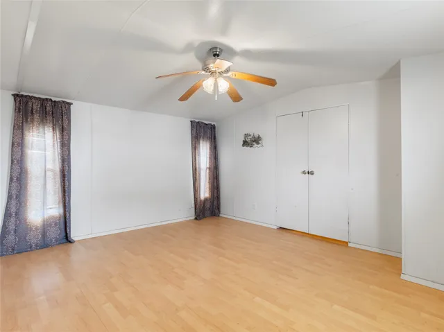 a view of an empty room and chandelier fan
