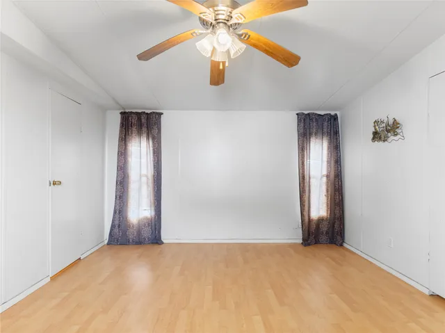an empty room with closet and fan