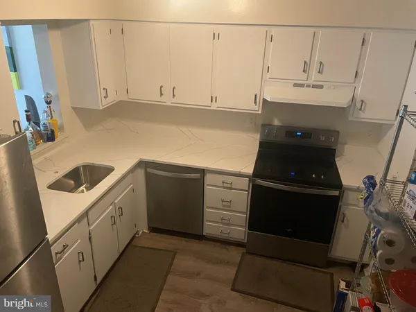 a kitchen with white cabinets and white appliances