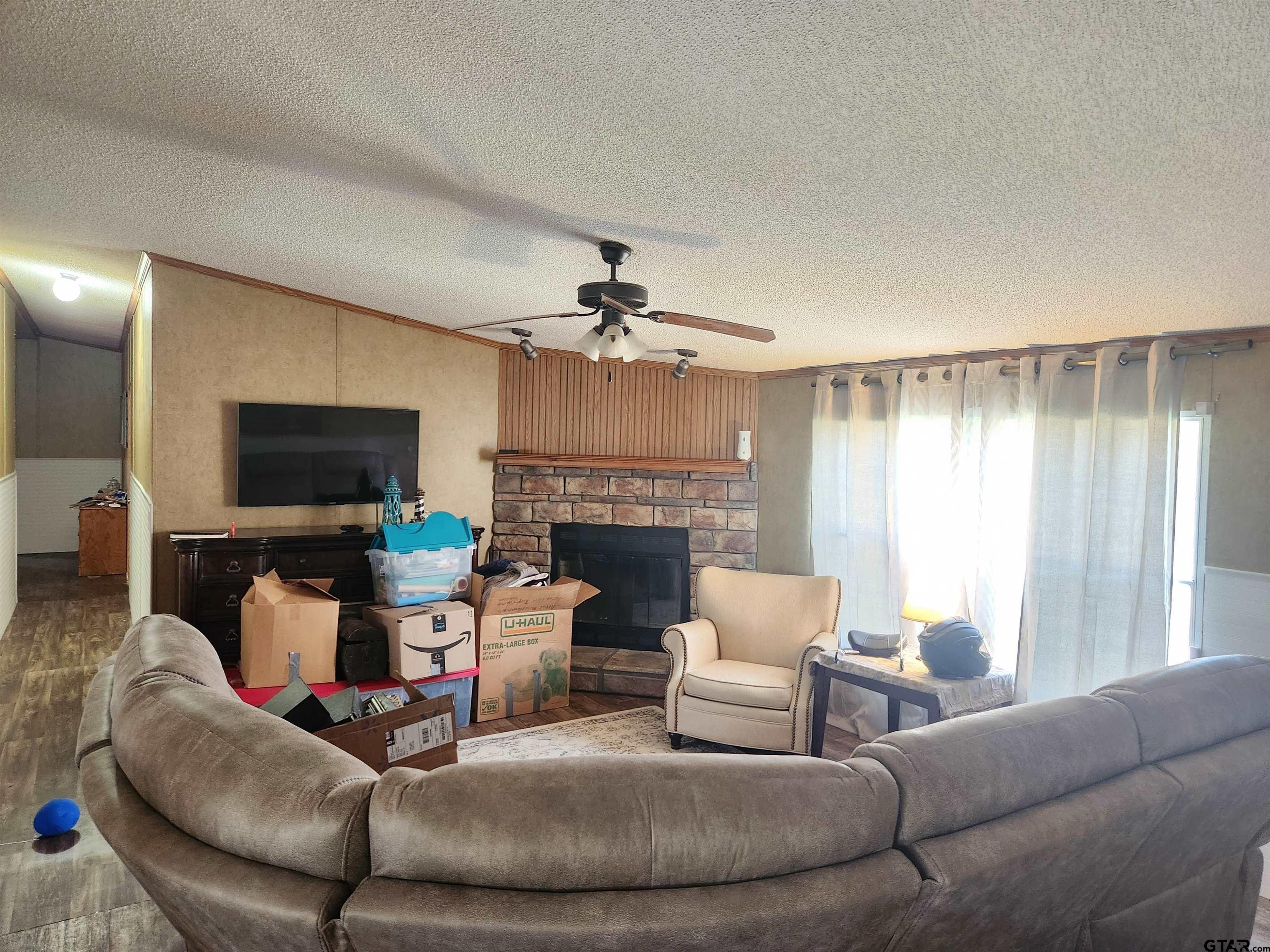 11308 E Creek Tyler, TX 75708 - Photo 2 of 14 a living room with furniture a flat screen tv and a fireplace