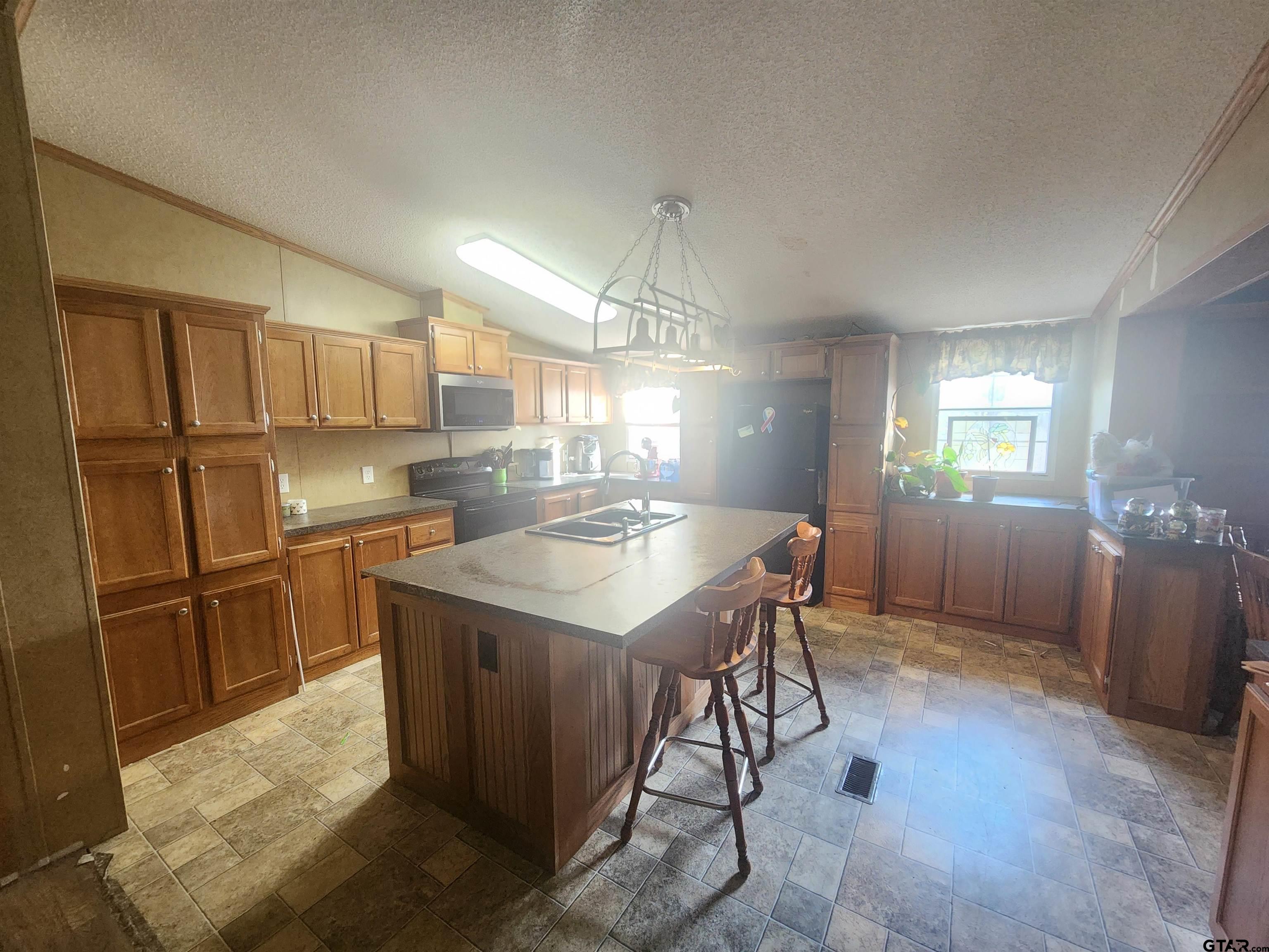 11308 E Creek Tyler, TX 75708 - Photo 4 of 14 a kitchen with granite countertop cabinets and refrigerator