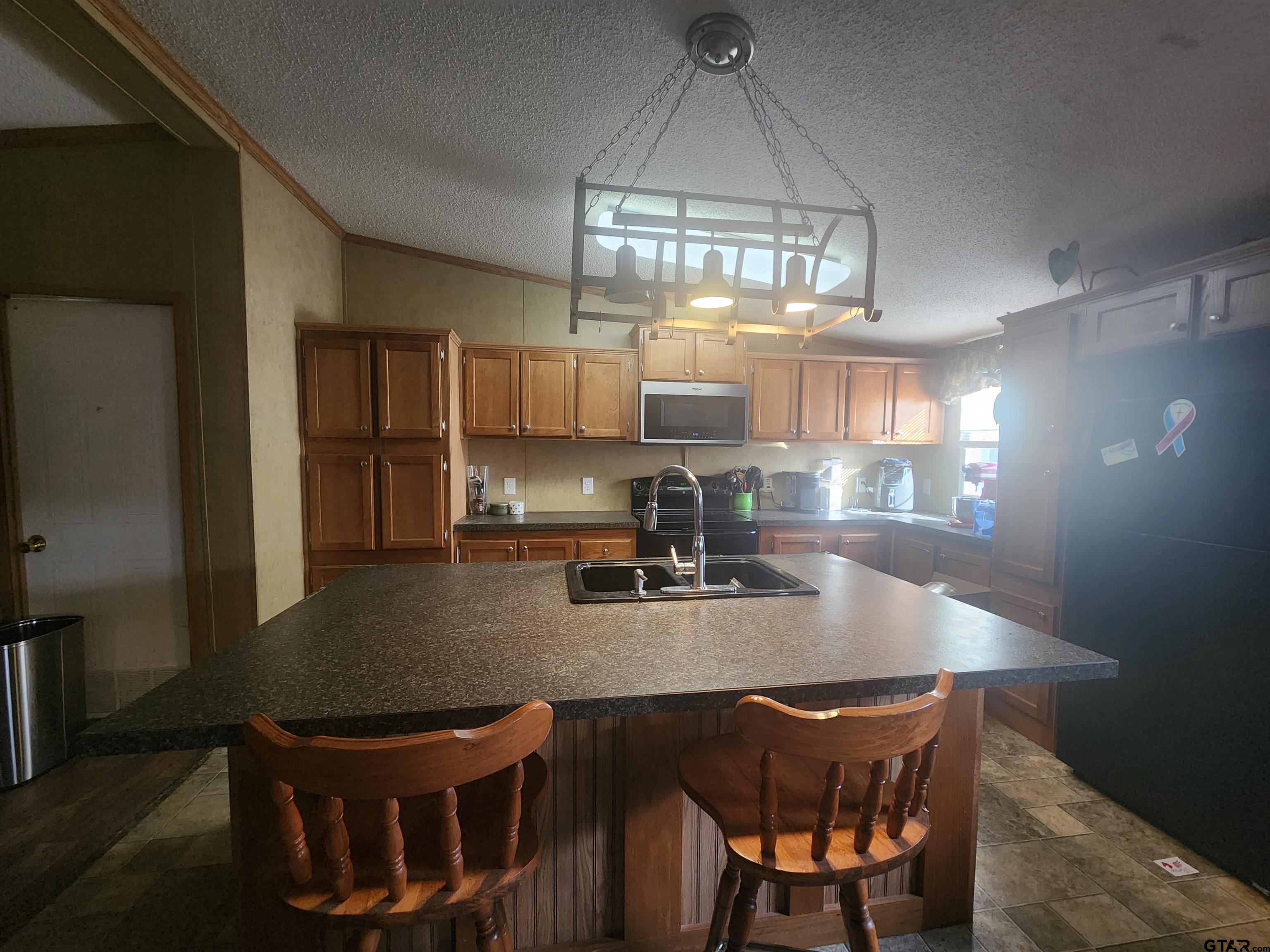 11308 E Creek Tyler, TX 75708 - Photo 5 of 14 a kitchen with a dining table chairs and refrigerator