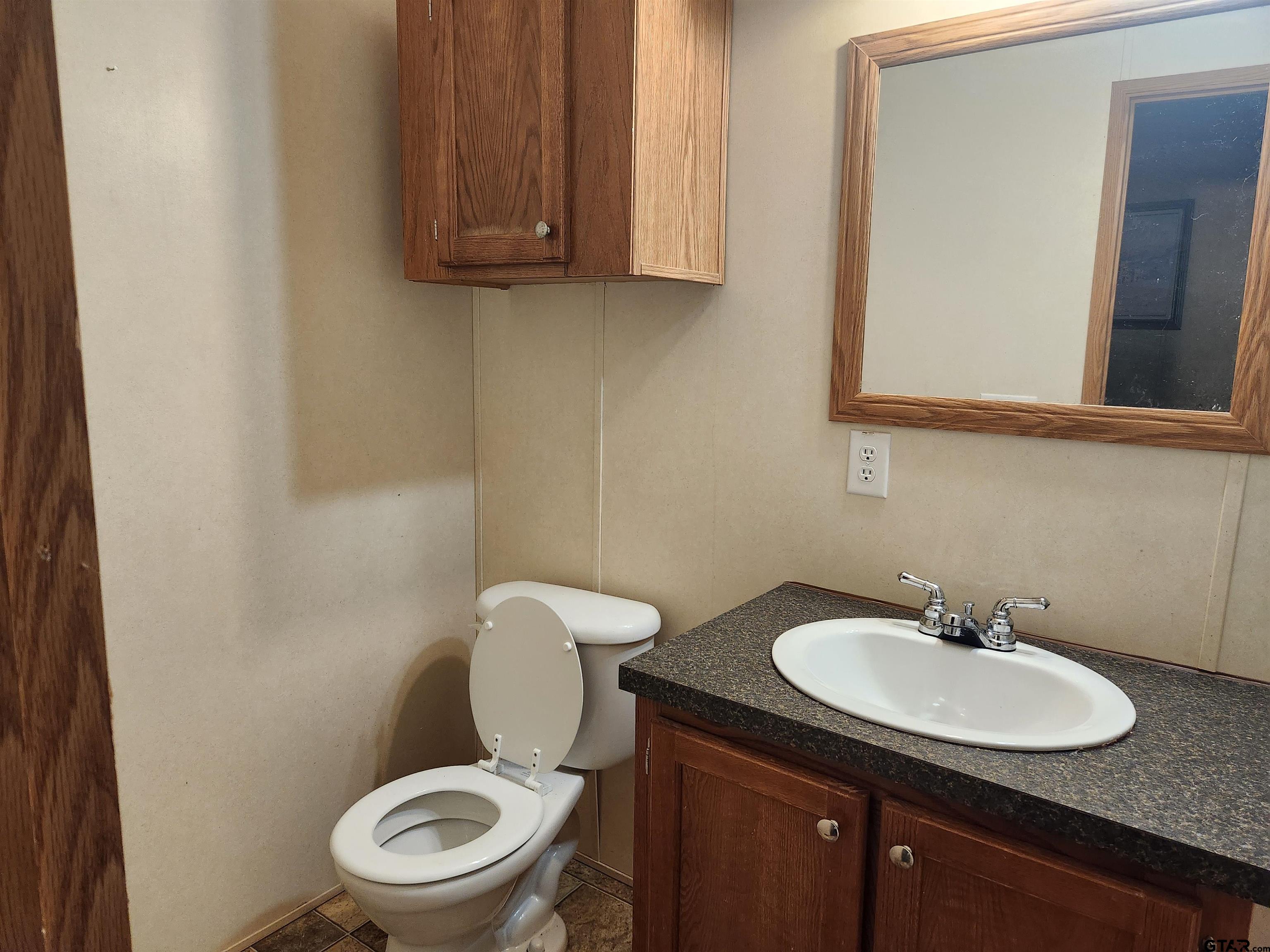 11308 E Creek Tyler, TX 75708 - Photo 10 of 14 a bathroom with a toilet a sink and mirror