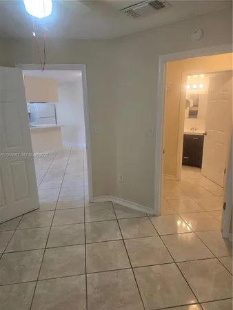 a view of a livingroom with wooden floor and a kitchen space