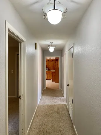a view of a hallway with wooden shelves