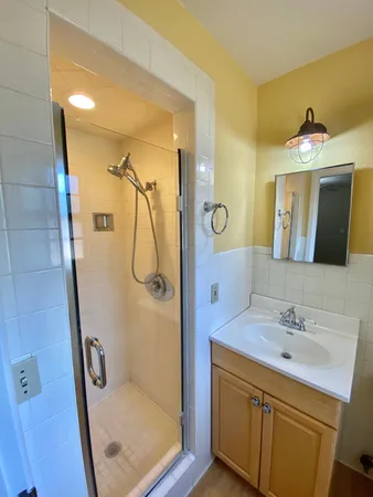 a bathroom with a shower sink and mirror