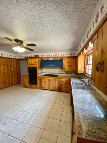 a kitchen with stainless steel appliances kitchen island granite countertop a sink and cabinets
