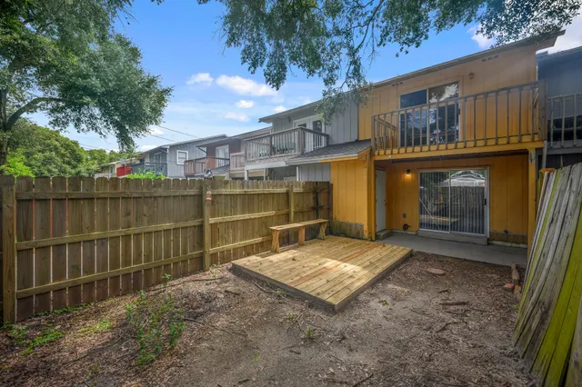 a view of a house with backyard and wooden fence