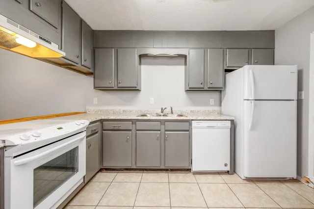 a kitchen with cabinets appliances a sink and a counter top space