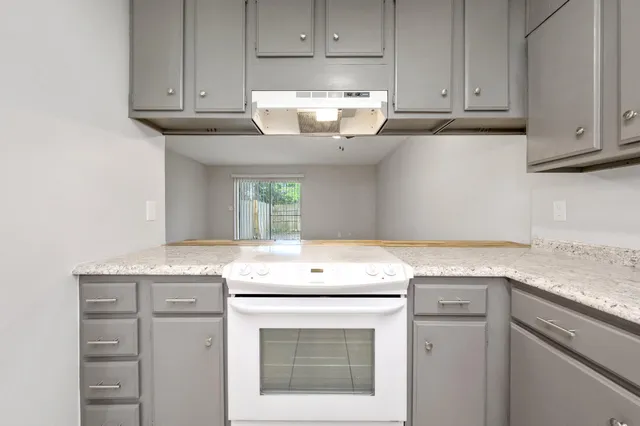 a utility room with granite countertop cabinets washer and dryer