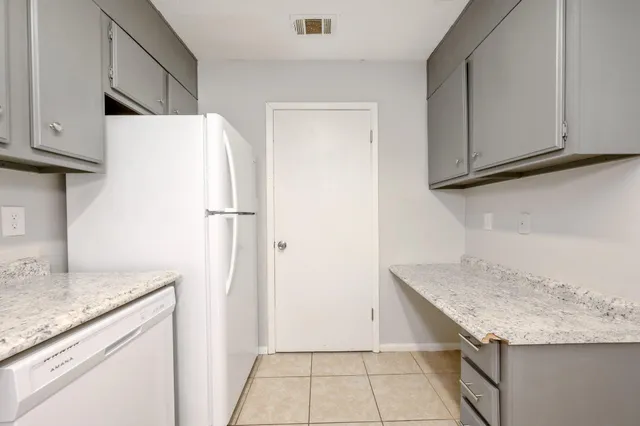 a kitchen with granite countertop a refrigerator and a sink