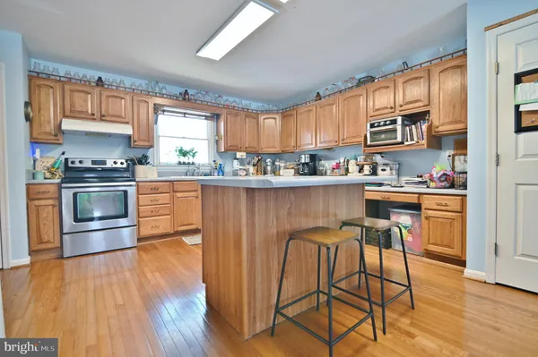 a kitchen with stainless steel appliances granite countertop wooden floors and table