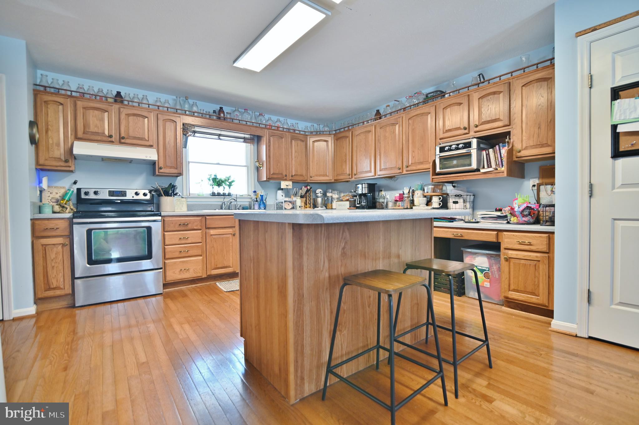 8284 Back Road Maurertown, VA 22644 - Photo 27 of 54 a kitchen with stainless steel appliances granite countertop wooden floors and table